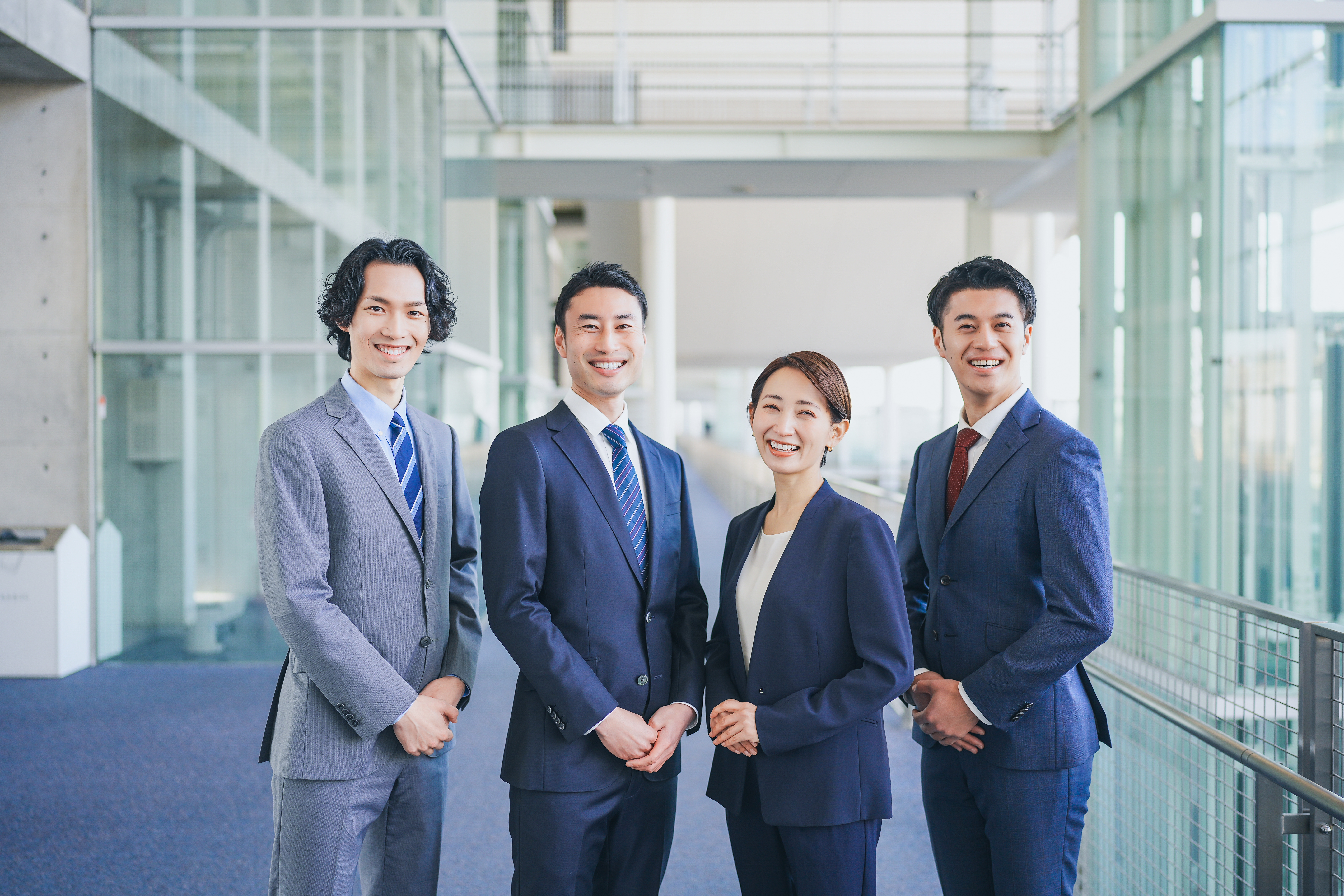 オフィスの廊下に並んで立つビジネスマンの男女